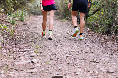 legs of a sporty couple walking in the forestの写真素材