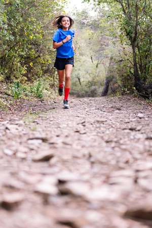 smiling girl practicing trail running at forestの写真素材