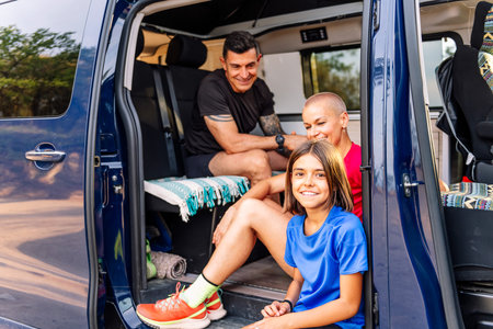 family resting in van after doing sports in nature