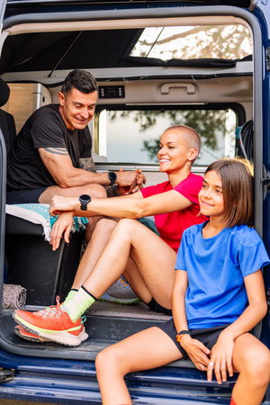 family resting in van after doing sports in nature