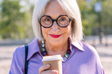 smiling senior woman with a takeaway coffee