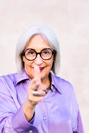senior woman pointing with fingers like a gun
