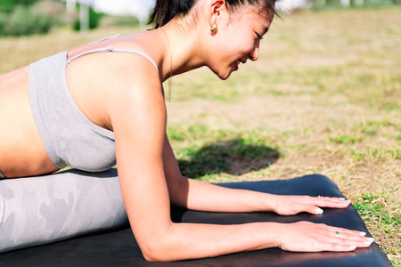 young asian woman doing yoga exercises in the park