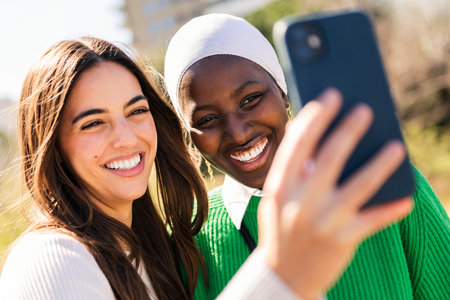 two friends smiling and having fun taking selfieの写真素材