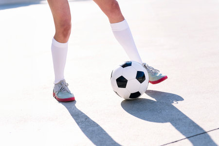 feet of a football player playing with soccer ball