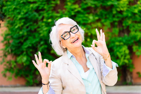middle age woman smiling happy and doing ok sign