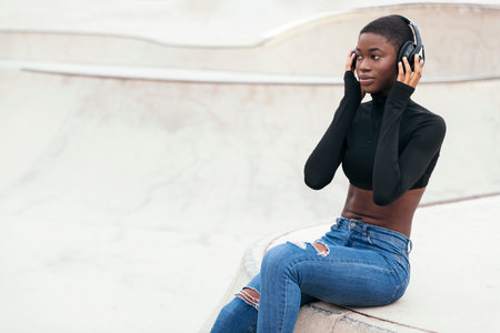 african american female in jeans listening musicの写真素材