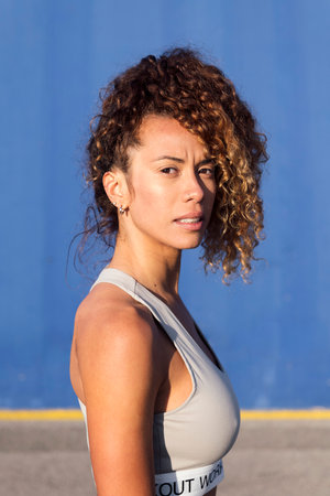 female athlete with curly hair looking at cameraの写真素材