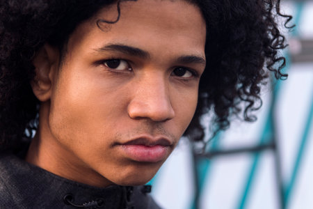 curly haired black male teenager looking at cameraの写真素材