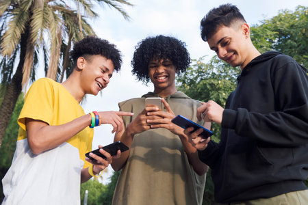 teen friends having fun using mobile phonesの写真素材