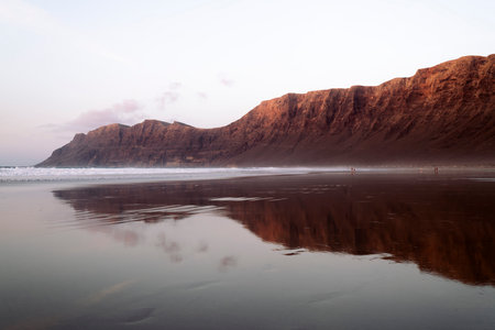panoramic view of beach under mountains and cliffの写真素材