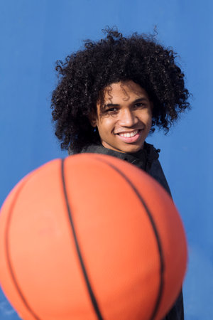 teen outstretching hand with basketball ballの写真素材