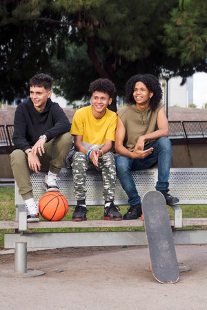 teen male friends smiling happy sitting on benchの写真素材