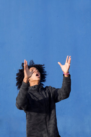 teen male with curly hair looking up surprised
