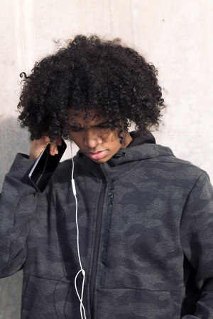 teenage boy with curly hair putting on earphones