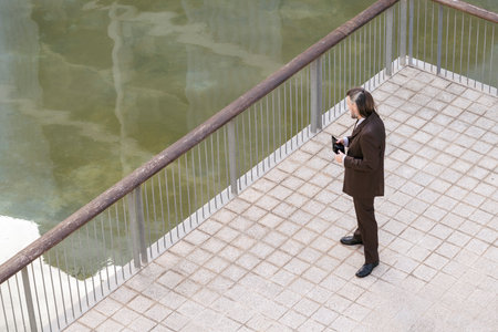 middle age male in elegant suit browsing on tabletの写真素材