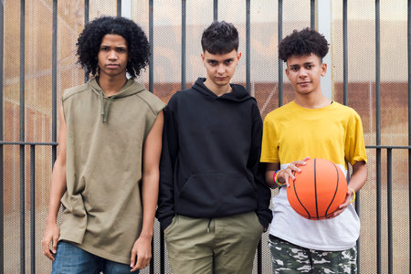 three multiracial male teenagers looking at cameraの写真素材