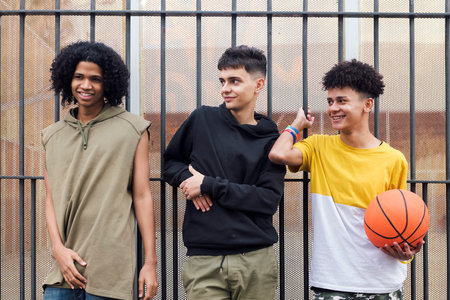 three multiracial male teenagers looking at cameraの写真素材