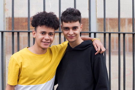 smiling latin man hugging teen friendの写真素材