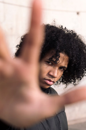 teen male with curly hair spreading handの写真素材