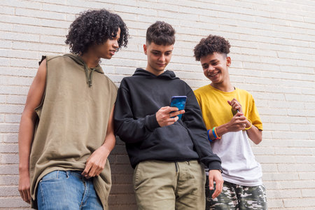 three diverse teens having fun using mobile phoneの写真素材