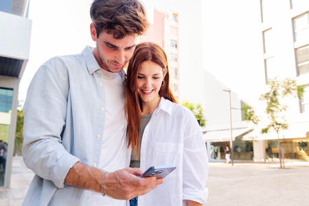 man and woman looking at a cell phone togetherの写真素材