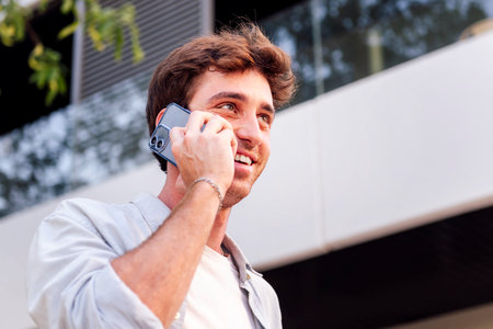 smiling man talking on cell phone at street