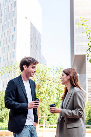 man and woman talking near office buildingsの写真素材