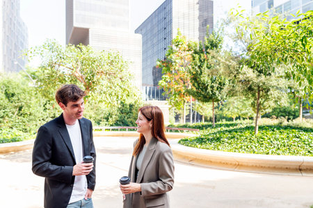man and woman talking near office buildingsの写真素材