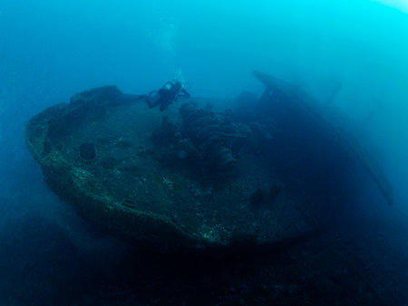 scuba diver diving on a sunken ship in the ocean