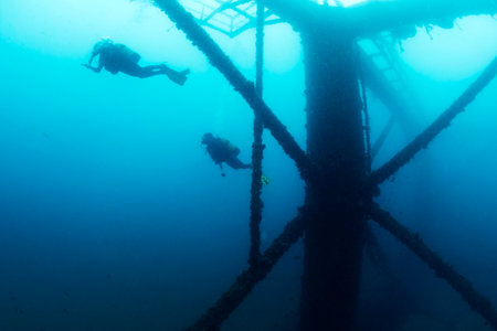 divers next to the structure of a wreck in the seaの写真素材