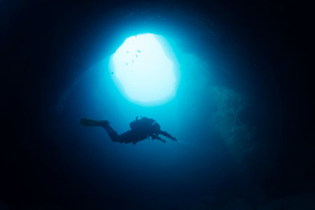 diver exploring inside an underwater caveの写真素材
