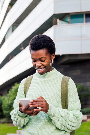 young woman smiling while looking her cell phone