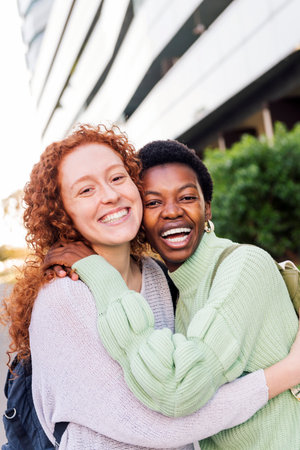 two young women hugging and smiling happyの写真素材