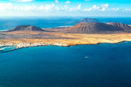 sunny day with some clouds where you can see a beautiful island with two mountains and its portの写真素材