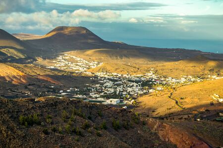 village in the lanzarote valley with all its white houses, surrounded by mountains and the sea in the background, beautiful views from the top of the mountainの写真素材