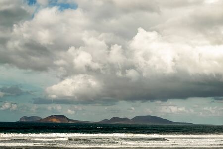 beautiful landscape of an island when the clouds approach, the calm sea brings peace to the photographの写真素材