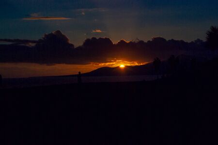 horizontal photography of summer landscape when the sun goes down and beautiful colors appear in the sky, the dim light of the beach dramatizes the photoの写真素材
