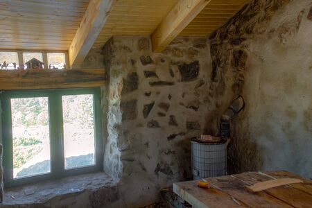 rustic and sober refuge for mountaineers who want to spend the night near the peÃ±alara peak, it is built in stone with an air of old construction, pine wood ceiling that gives it a warm touch, a wood stove and a small window with a beautiful landscapeの写真素材