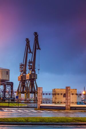 port of coruÃ±a, standing at night its two old cranes you rest with your arm raised waiting for the next day's activity to startの写真素材