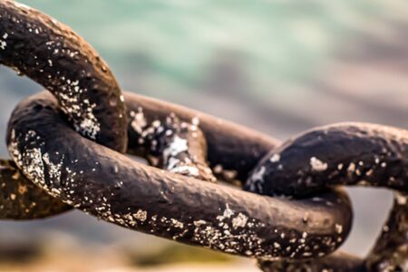 great chain of old and rusty iron that remains attached despite the elements and adversities, is strong and hard nothing can separate itの写真素材