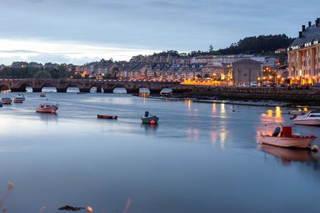 night landscape of the burgo estuary, with the boats resting at night, they are watched by the buildingsの写真素材