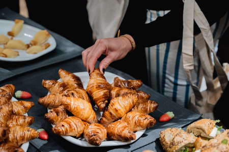 croissants in a plate held by a womanの写真素材