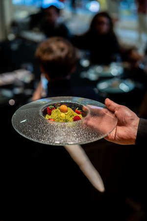 appetizing dessert with candies held by a waiter in a restaurantの写真素材