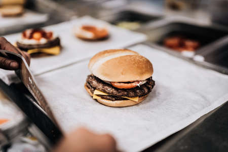 hands preparing a hamburger sandwich