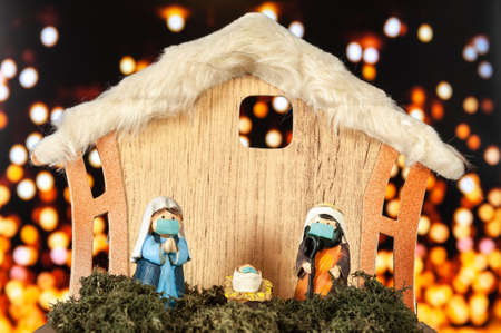 Christmas nativity scene with figurines on a background of yellow out-of-focus lights