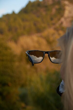 Look at the mountain through other eyes. Looking through the glassesの写真素材