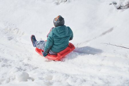 Playing with the sled in the snowy mountain. Holiday games