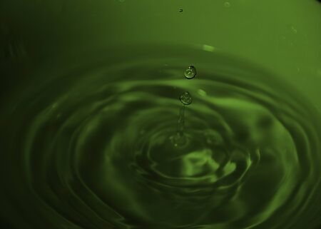 Drop of water on white bowl, green tones, bluish, waves,の写真素材