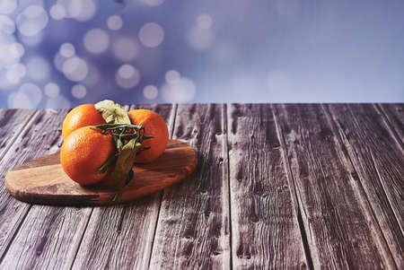 Various oranges on wooden table on wooden floor and bright backgroundの写真素材